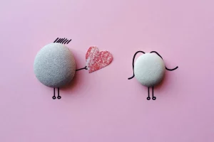 Charming stone art with heart symbol on pink background, symbolizing love and connection.